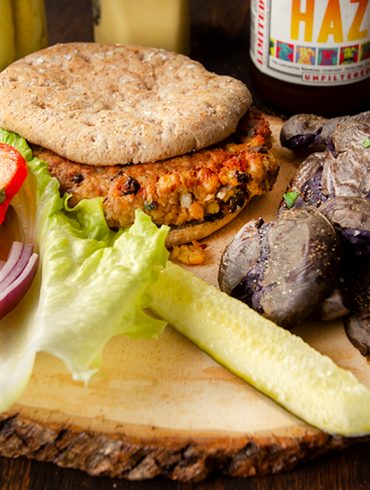 Smashed potatoes pictured with a veggie burger and fixings