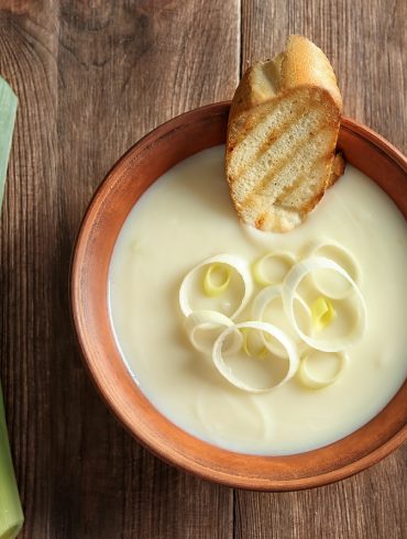 Bowl of Creamy Potato Leek Soup with a slice of crusty bread